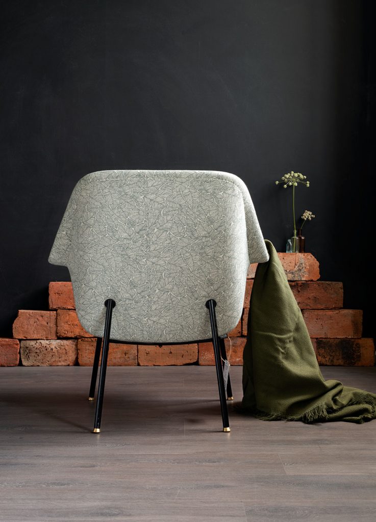 Kunnostettu Havui-nojatuoli 50-luvulta (jalat: putkirunko, istuinrunko taivutettua vaneria), kankaana: Ruska-kuosi väreissä pullonvihreä/valkoinen. Tuoli kuvattuna takaapäin.