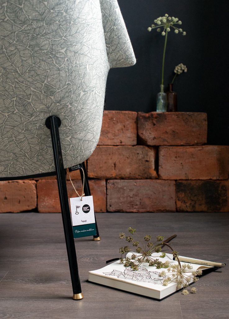 Kunnostettu Havui-nojatuoli 50-luvulta (jalat: putkirunko, istuinrunko taivutettua vaneria), kankaana: Ruska-kuosi väreissä pullonvihreä/valkoinen. Yksityiskohta selästä.